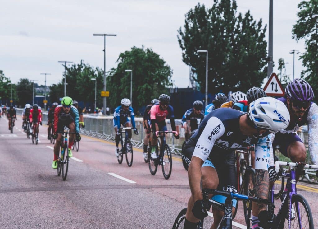 Cyclistes en compétition, en pleine course sur une route urbaine, concentrés et en pleine performance.